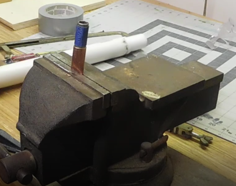 large vise flattening copper tubing to make a lug