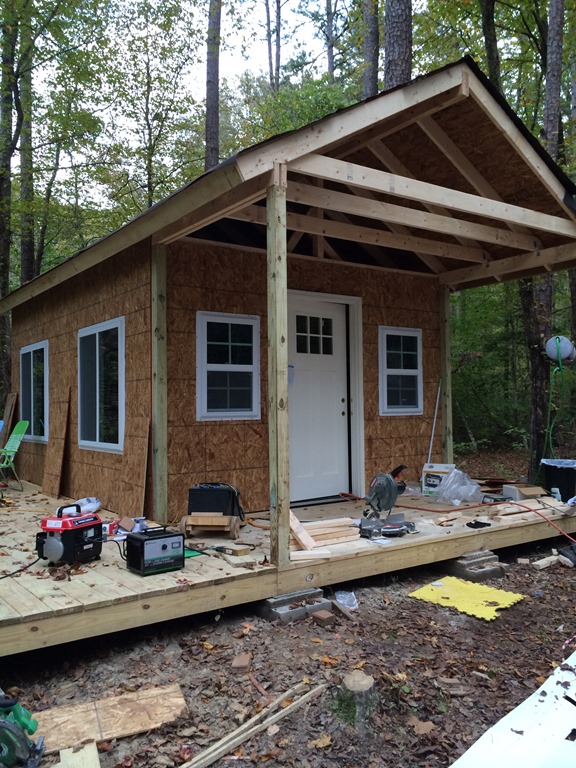 Windows and wall sheathing installed on the tiny cabin