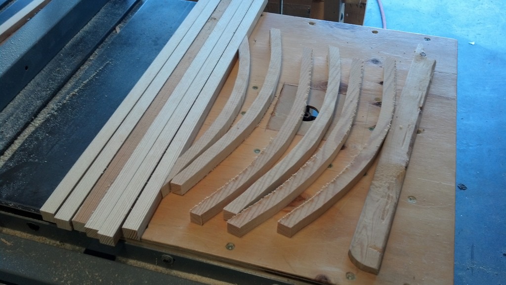 Curved wooden back supports marked and cut for a backpack frame
